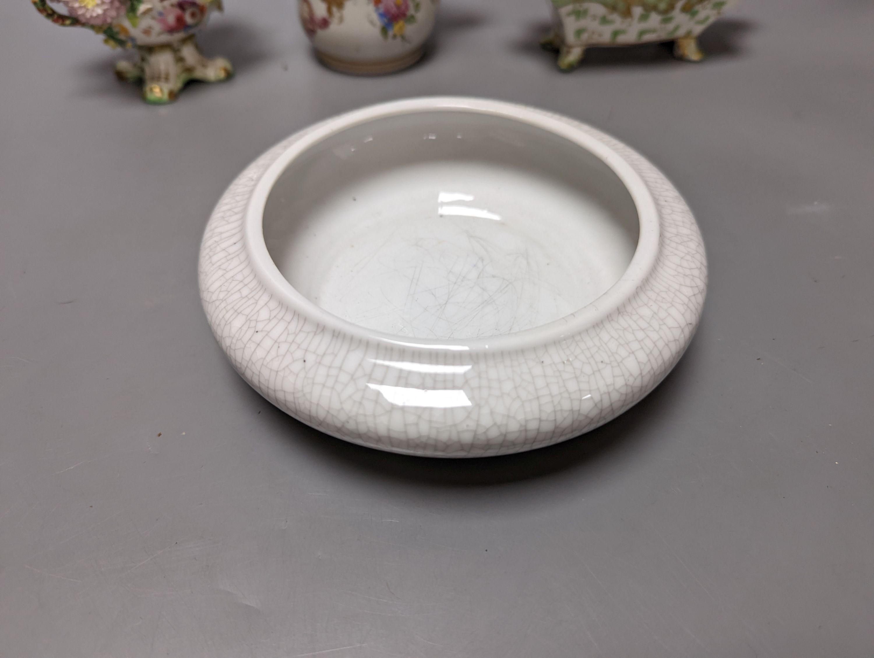 A Meissen style chocolate cup and cover, two mid 19th century English porcelain flower encrusted pots and covers and two dishes